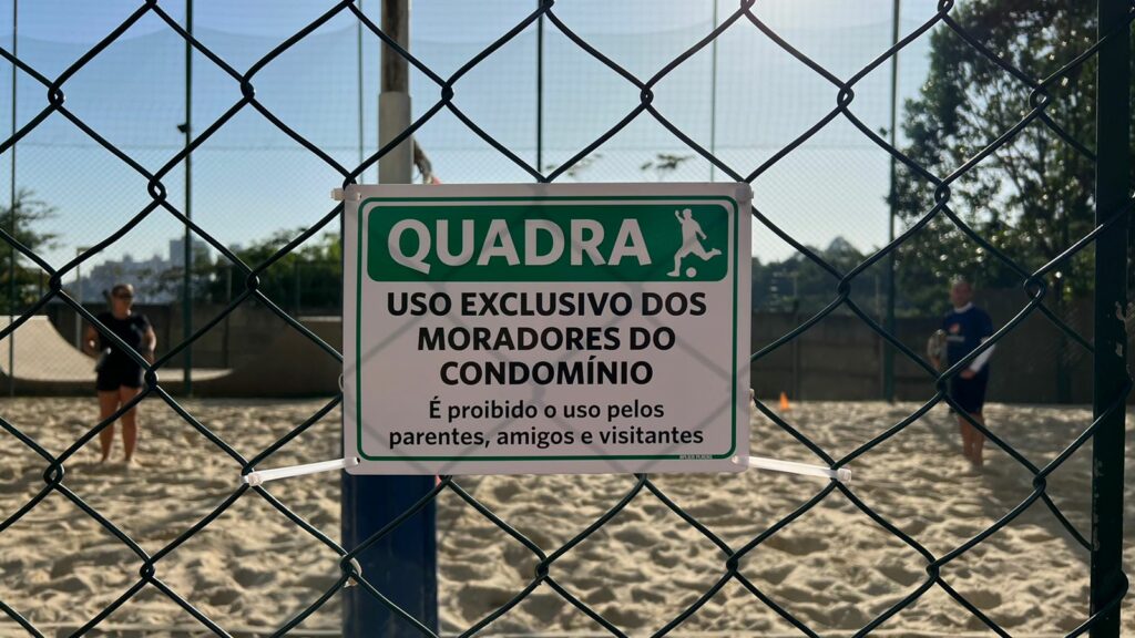 Aviso em quadra de beach tennis em condomínio alerta para uso exclusivo de moradores