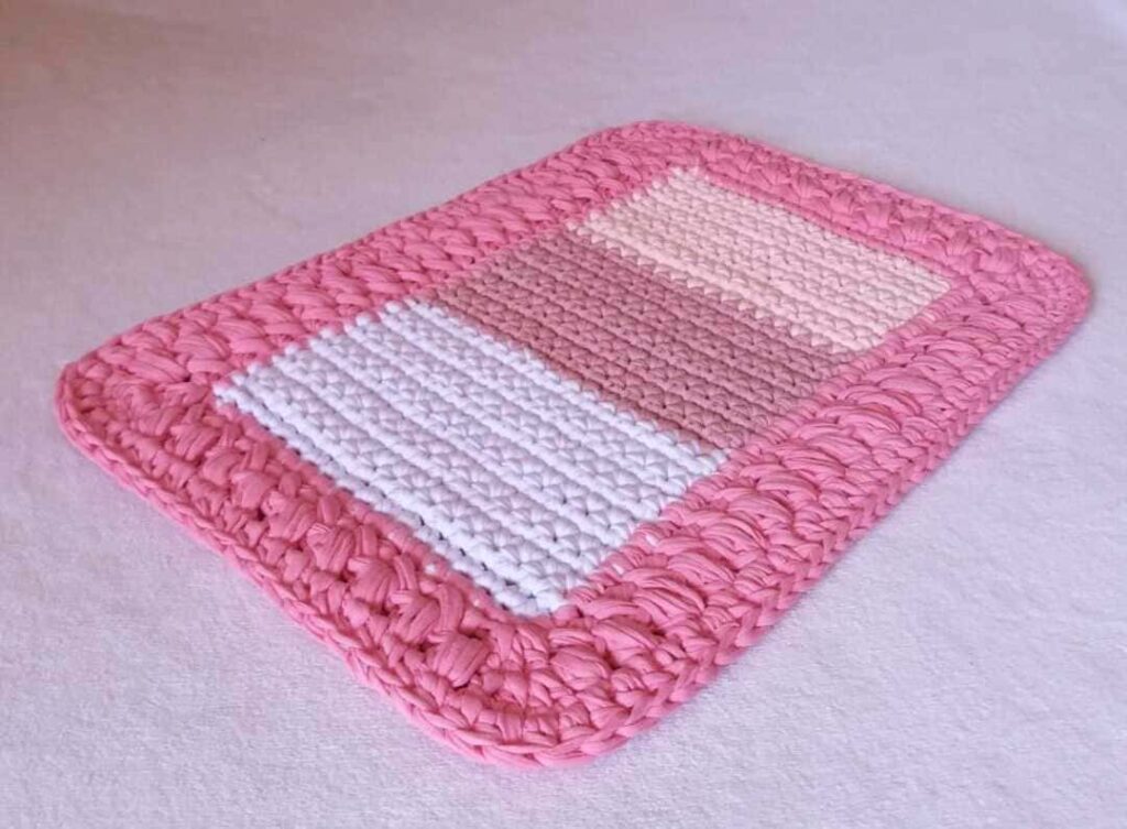 Tapete de crochê feito de malha, retangular, com ponto grosso, nas cores rosa e branco