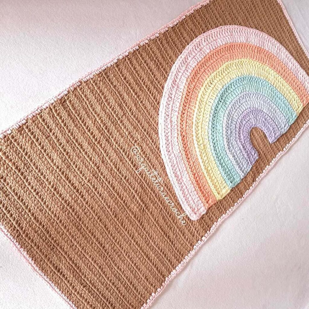 Tapete de crochê para quarto de bebê retangular, em marrom, com o desenho de arco-íris em alto relevo