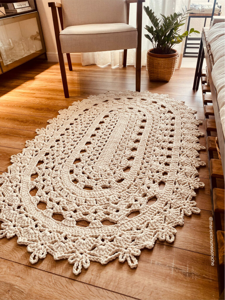 Tapete de crochê tradicional, oval, cru, feito com barbante bastante espesso, o de 32 fios, e ponto largo
