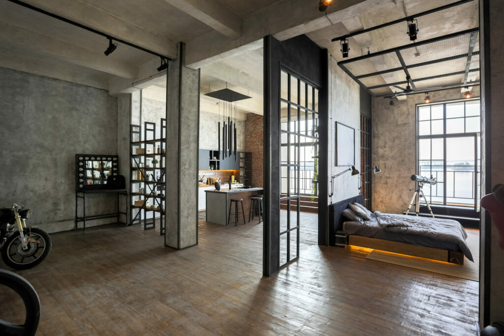 Estilo rústico, com estrutura industrial, marcam os lofts tradicionais. Nesse, a integração entre os ambientes do quarto, sala e cozinha, sem paredes, e com piso de madeira