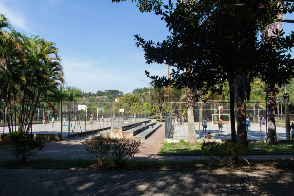 Parque Lions Clube Tucuruvi  com árvores e duas quadras de esporte com pessoas jogando