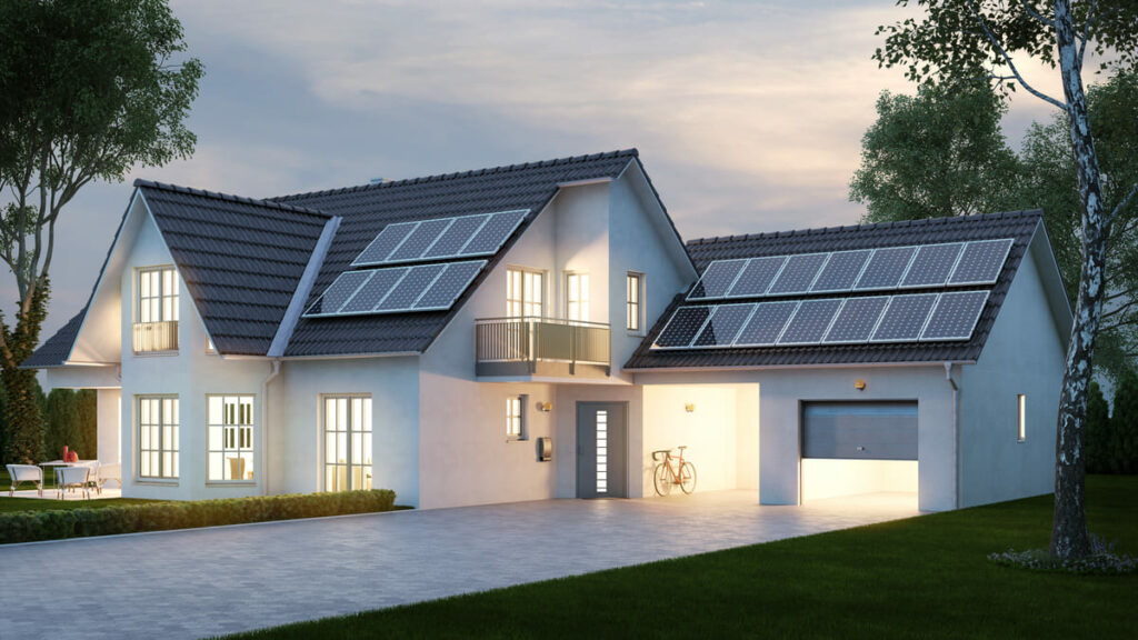 Fachada de casa branca com telhado tradicional cinza escuro com placas de captação de energia solar