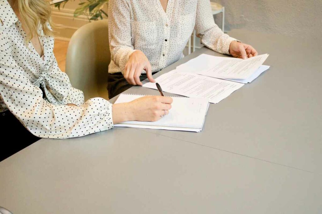 Mulheres assinando um contrato com cláusula resolutiva