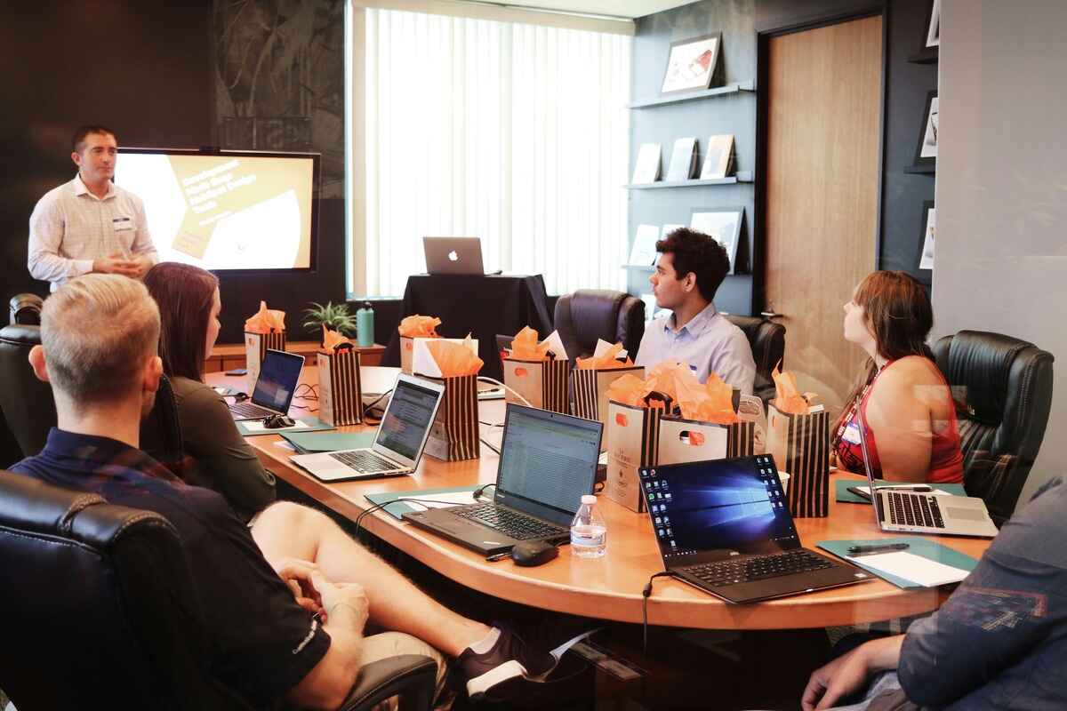 Pessoas numa sala de reunião em um curso para time de vendas