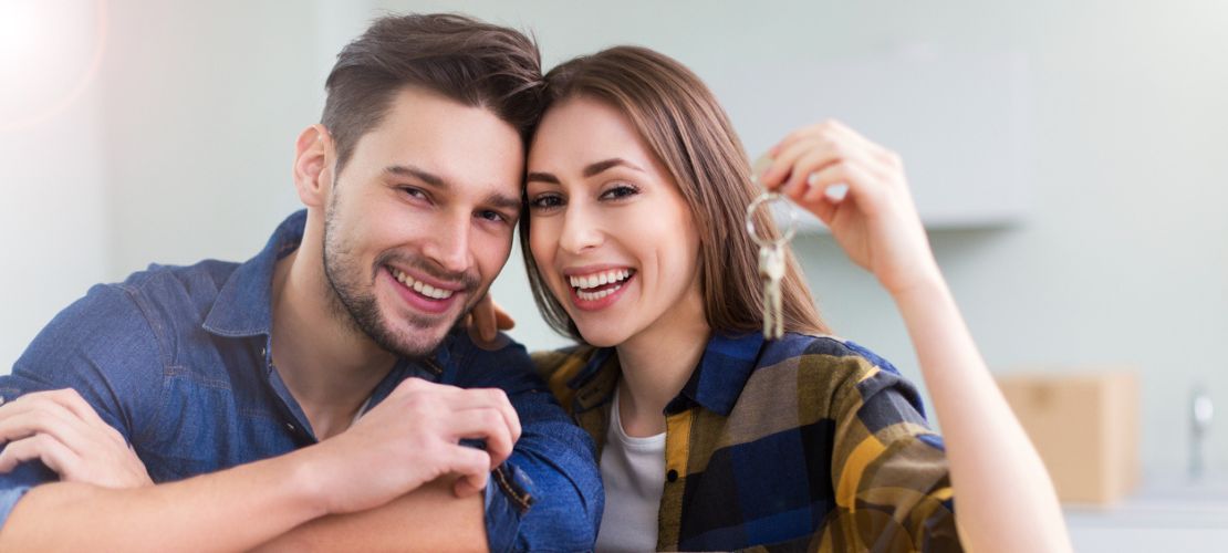 Casal feliz com a chave do novo imóvel